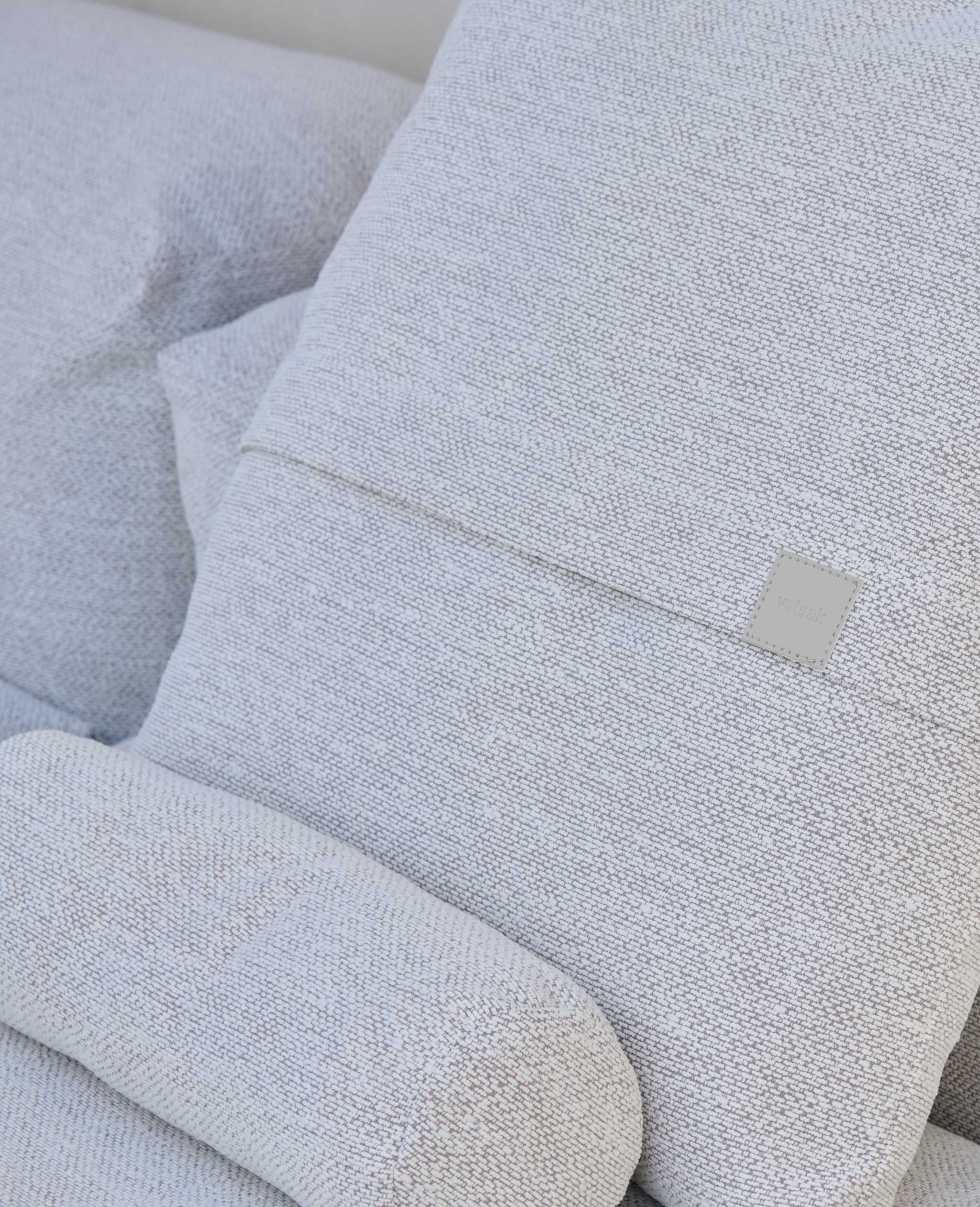 Nahaufnahme des hellen Stoffbezugs eines vetsak Sofas mit weicher Polsterung und dekorativem Kissen.